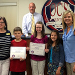 From L-to-R: Beaver Dam Elementary Principal Michelle Magan, Isaac Shepherd, Emily Sisk, Jalyn Anderson and teacher Bonnie Simpson stand in front of Ohio County Schools Superintendent Scott Lewis after the students received certificates of appreciation at the last OC School Board meeting.