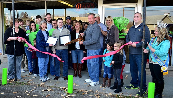Donnie Pearson, owner of The Trophy House of Ohio County, cuts the ribbon at a ceremony provided by the Ohio County Chamber of Commerce on Saturday at the business' new location.