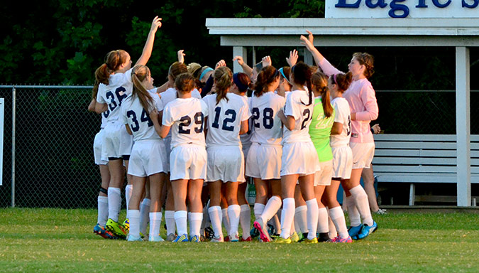 The Lady Eagles huddle up before their match with the Muhlenberg County Lady Mustangs.