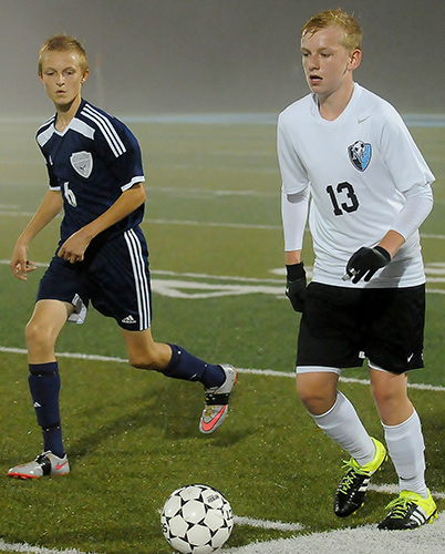 Muhlenberg County's Justin Labes, right, brings the ball up the field as Eagle Justin Gordon defends.