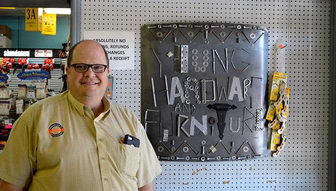 Jim Acquaviva, one of Young’s Hardware & Furniture stockholders, stands next to an art piece that his daughter, Marybeth Acquaviva, made using various hardware parts. After serving Ohio County and the counties beyond for 85 years, the store’s last business day will be on Oct. 10.